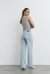 Jean wide leg de tiro bajo, color celeste, con apliques de brillos sutiles en toda la prenda.