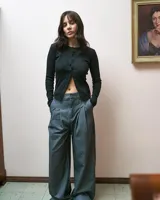 Pantalón sastrero gris de corte ancho con pinzas en la cintura y bolsillos laterales.