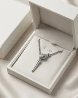 Collar de acero con cadena de eslabones tipo veneciana y colgante en forma de cabeza de serpiente con incrustaciones de circonias y ojos verdes, finalizado con un dije alargado en forma de punta.