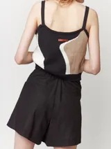 Short color beige de lino con tiro alto, elástico en la pretina trasera, cierre delantero con botón, tablas en el frente, bolsillos delanteros y dobladillo invisible.