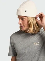 Gorro tipo beanie de lana en color crema, con tejido acanalado y parche con estrella negra en el frente.