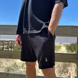 Short de tejido texturizado color beige, con cintura elastizada y cordón ajustable.