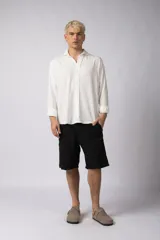 Camisa de manga larga con cuello clásico y cierre frontal de botones. Presenta un calce relajado y una textura liviana.