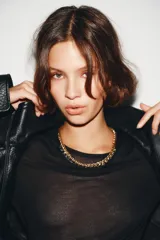 Collar tipo gargantilla de eslabones trenzados en tono dorado, con pequeños colgantes en forma de pirámide o cono en tono oscuro (negro/gris) colgando a lo largo de la parte inferior. Posee un cierre de caja cuadrado en la parte trasera.