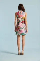 Vestido corto sin mangas con cuello alto y lazo colgante, de diseño recto y estampado floral multicolor sobre base rosada.