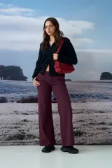 Cardigan negro de punto con cuello tipo polo y cierre frontal de botones. Presenta un diseño de textura acanalada y corte ajustado.