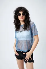 Top de manga corta, corte holgado, confeccionado en tejido de malla translúcido con brillo metálico y estampado tipo paisley en tonos azules.