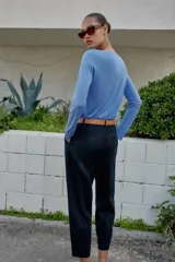 Pantalón tobillero azul marino de tiro medio, con pinzas delanteras, bolsillos frontales, falsos bolsillos con solapa en la espalda y cierre frontal con cremallera, botón y gancho. Incluye cinturón de cuero sintético tostado con hebilla metálica dorada.