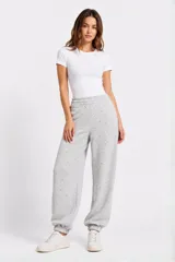 Babucha gris melange de corte relajado, con cintura elástica fruncida y puños en los tobillos. Presenta pequeños apliques brillantes distribuidos por toda la prenda.