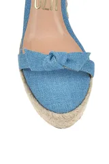 Sandalias con plataforma de yute y tiras de tela celeste con estampado tie-dye.