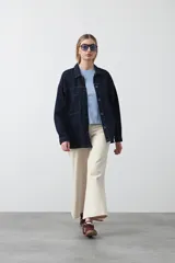 Remera de manga corta y cuello redondo, confeccionada en algodón. Presenta costuras verticales visibles en el frente que generan un efecto de entalle y estructura en la cintura.