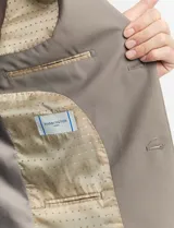 Ambo de corte clásico compuesto por saco de dos botones y pantalón de vestir a juego. El saco cuenta con solapas de muesca, bolsillos laterales con solapa y un bolsillo en el pecho. El pantalón presenta un corte recto y limpio.