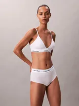 Bralette de triángulo Calvin Klein, confeccionado en una mezcla de algodón y modal. Presenta copas ligeramente forradas, tirantes ajustables y la icónica banda elástica con el logo de la marca. Diseño sin aros para mayor comodidad.