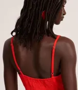 Mono de mujer color rojo, de corte recto y pierna ancha, con breteles finos ajustables y escote corazón. Presenta un detalle fruncido en la espalda (lastex).