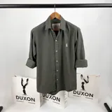 Camisa de vestir verde musgo, de corte clásico, con cuello italiano, manga larga con puños abotonados y logo bordado en el pecho.