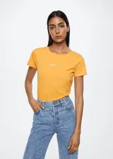 Remera color naranja de corte recto, cuello redondo y manga corta. Estampado frontal con el logo de Mango.