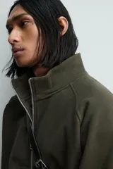 Sudadera de algodón con interior en rizo afelpado, cuello subido, manga larga y cierre frontal de cremallera. Presenta un efecto lavado que le da una apariencia única y bolsillos frontales ocultos en las costuras.