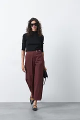 Pantalón wide leg de corte sastrero, color negro, con cintura de tiro medio y diseño de pernera amplia y relajada.