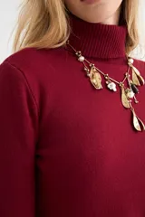 Polera de cuello alto y manga larga, confeccionada en tejido de punto fino con puños y ruedo acanalados.