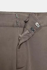 Pantalón recto color gris topo, de tiro medio, con bolsillos delanteros y falsos bolsillos de doble vivo en la espalda. Cierre frontal con cremallera, botón interior y ganchos.