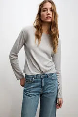 Jeans celeste de tiro alto, corte recto y largo, con cinco bolsillos y cierre frontal con cremallera y botón.