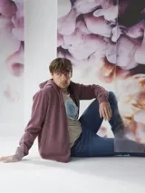 Buzo tipo hoodie con cierre frontal completo, capucha con cordones ajustables y bolsillos laterales. Confeccionado en tejido de algodón con textura jaspeada.