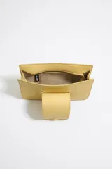 Bandolera amarilla de cuero con correa de cadena dorada y cierre con solapa con logo metálico.