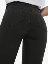 Pantalón jean skinny de tiro alto en color negro, con bolsillos delanteros y traseros, confeccionado en denim elástico.