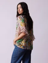 Blusa de gasa estampada con cuello a la base y lazo. Tiene plisado en la delantera, detalles de brillo en lurex, abertura central con botones y mangas 3/4 fluidas.