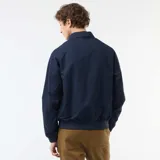 Campera tipo bomber azul marino de twill, con cierre frontal, bolsillos laterales, cuello camisero y puños y cintura elastizados.