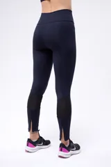 Calza negra de running de tiro alto, confeccionada en poliamida y elastano, con cierre en los tobillos.