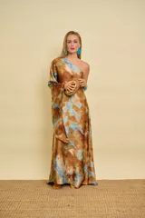 Vestido túnica largo de satén con diseño de un solo hombro, una manga larga amplia y estampa tipo tie-dye en tonos marrón y celeste.