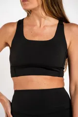 Top deportivo negro con breteles anchos y espalda deportiva.