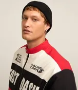 Gorro tipo fisherman de tejido acrílico con textura acanalada, diseño corto y etiqueta pequeña con logo en el frente.