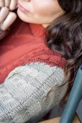 Sweater de punto con diseño de ochos y estilo patchwork, combinando paneles en colores terracota, marrón y beige. Presenta cuello redondo, mangas largas y costuras decorativas a la vista.