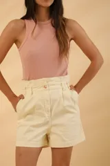 Short color crudo de tiro alto con cintura paper bag, bolsillos laterales y cierre frontal con botón.