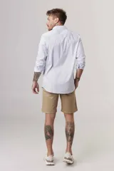 Camisa celeste a rayas verticales blancas, de corte slim fit, con cuello clásico y mangas largas.