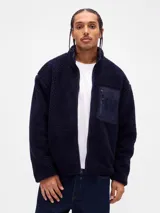 Campera de polar tipo sherpa color azul marino, con cierre frontal completo, cuello alto y bolsillo frontal con cierre y logo de la marca bordado.