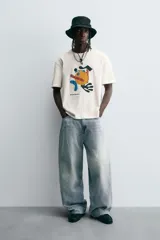 Jeans de denim de algodón, color azul oscuro con efecto lavado. Presentan un corte muy holgado (baggy fit) en toda la pierna y tiro medio. Tienen cinco bolsillos y cierre frontal con cremallera y botón.