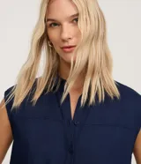 Vestido chemise midi azul marino de Marfinno, confeccionado en mezcla de lino y viscosa. Presenta cierre frontal de botones, cuello camisero, sin mangas y bolsillos laterales.