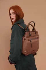 Cartera mochila de diseño versátil color marrón, confeccionada en material sintético impermeable. Cuenta con doble asa superior, correas ajustables para usar como mochila, bolsillo frontal con cierre y compartimento principal espacioso.