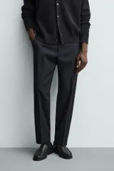 Pantalón de vestir regular fit color negro, confeccionado en tejido con mezcla de lana y elasticidad. Cuenta con cintura elástica, bolsillos frontales, bolsillos traseros de vivo con botón, y cierre frontal con cremallera y botón.