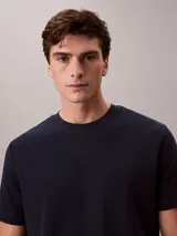 Remera de corte regular confeccionada en algodón, con cuello redondo y mangas cortas. Presenta un diseño minimalista con el logo de la marca sutilmente bordado en el pecho.