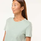 Conjunto de pijama color verde con estampado de estrellas blancas, compuesto por una camiseta de manga corta y un pantalón largo de corte recto.