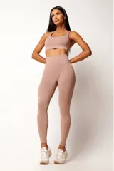 Top deportivo color rosa nude, con breteles anchos y espalda tipo nadador. Confeccionado con tecnología seamless y textura acanalada. Incluye forro y apertura para almohadillas.