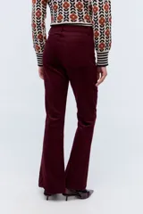 Pantalón de pana color bordó, corte oxford, con cintura alta y cierre frontal con botón y cremallera.