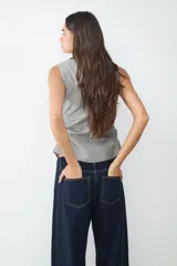 Top sin mangas con cuello camisero, escote en V profundo y detalle fruncido en los laterales. Confeccionado en tejido a rayas.