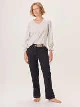 Pantalón de vestir azul marino, corte cigarette con pierna angosta y abertura en el bajo. Presenta costuras en contraste color beige y un botón marrón en la cintura.