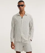 Camisa de manga larga Marfinno para hombre, de corte comfort y estilo sastre, confeccionada en poliéster blanco con rayas verticales negras. Presenta cuello inglés y cierre frontal de botones.