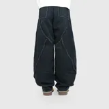 Pantalón de jean estilo ultra baggy color negro, con costuras decorativas con efecto desflecado en el frente. Presenta un corte holgado y amplio en las piernas.